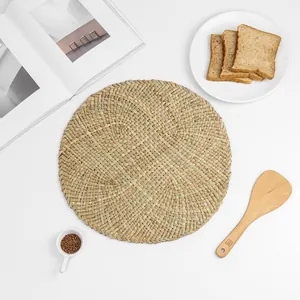 Detail of hand-woven round seagrass placemat showing natural texture and spiral pattern