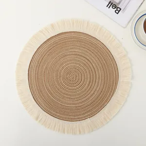 Detailed top view of a circular woven ramie placemat with rustic brown center and cream tassels