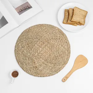 Detailed close-up of a hand-woven round natural seagrass placemat with organic texture