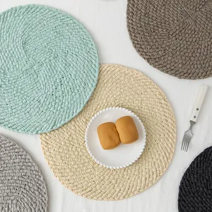 Close-up of colorful round hand-woven table mats with intricate braided texture and tassels