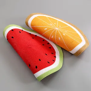 Makroaufnahme runder gewebter Tischsets mit leuchtenden Wassermelonen- und Orangendesigns