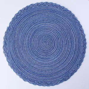 Detail of round woven placemat with blue and white spiral pattern and scalloped edges