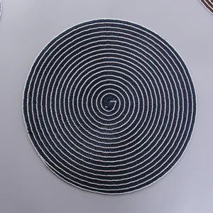 Detailed top view of a round blue and white woven placemat with a spiral texture