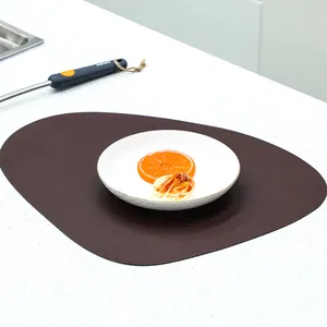 Waterproof dark brown irregular leather placemat with white ceramic plate on table
