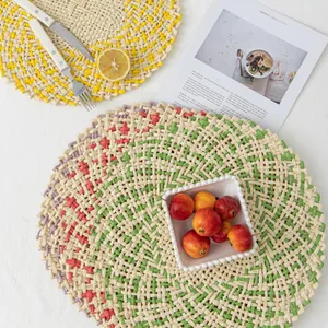 Close-up of hand-woven round placemats with fringe details and ethnic textured patterns
