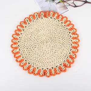 Detail showing handcrafted round woven placemat with orange scalloped edge