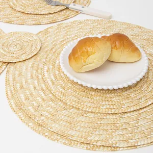 Macro detail of handwoven straw placemat set with natural fiber texture on white table