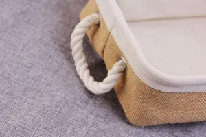 Detail of jute storage basket featuring thick rope handles and soft white inner lining