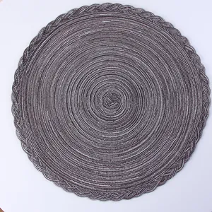 Close-up of circular woven placemat with dual-tone spiral texture and braided edge detail