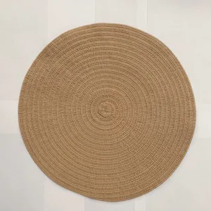 Detailed top view of light brown ramie placemat with circular spiral woven texture