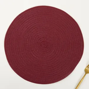 Detail of burgundy woven ramie placemat with a spiral texture and a golden fork