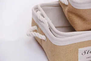 Close-up of nested jute storage baskets with white rope handles and fabric lining