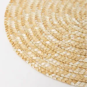 Macro detail of natural straw woven round placemat showing spiral texture and heat resistance