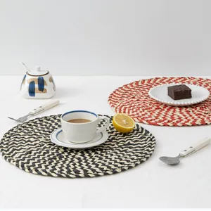 Macro detail of hand-woven round placemats featuring a classic herringbone pattern weave