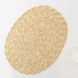 Macro detail of oval woven placemat with dual-tone natural straw and white braid patterns