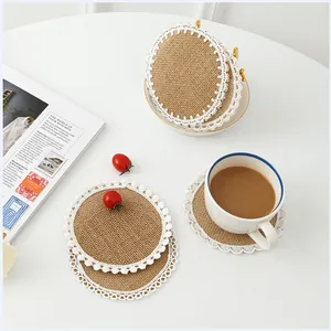 Detail of round jute placemats with white lace trim and decorative pom-pom edges