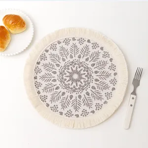 Top view of bohemian woven cotton coaster with gray leaf mandala print and fringed edges
