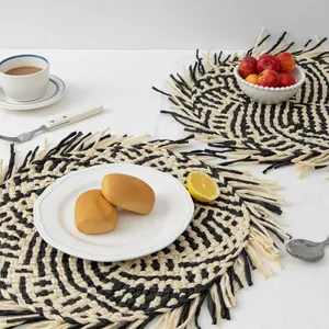 Handwoven round tassel placemats with black and white spiral patterns for table decor