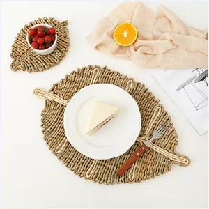 Leaf-shaped hand-woven straw placemats set in natural fiber for dining table decor