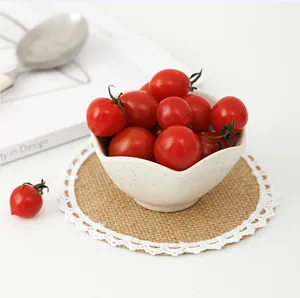 Ceramic bowl with blue splatter dots on a lace jute placemat with cherry tomatoes