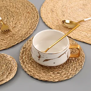 Close-up of hand-woven seagrass placemats with spiral texture on a gray table