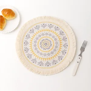Detailed top view of round woven mandala placemat with fringe and sun pattern motif