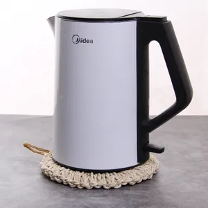 Detail of round hand-woven straw insulation pad under a modern electric kettle on counter