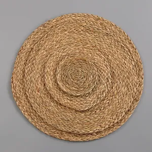 Detailed top view of three stacked natural seagrass woven placemats in different sizes