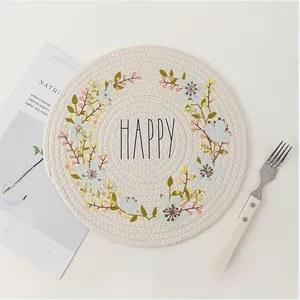 Detailed view of round Nordic woven placemat with happy slogan and floral print