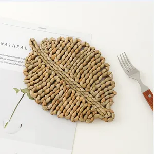 Detail of leaf-shaped woven placemat showing natural texture and spiral braided pattern