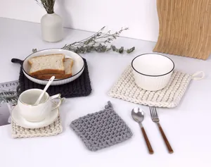 Close-up of thick square woven cotton heat pads with hanging loops in neutral tones