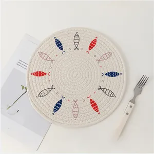 Close-up of Nordic woven round placemat with fish pattern and thick heat insulation