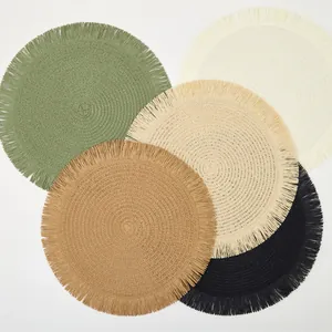 Detail of round woven placemats with fringe edges in five earthy colors on white background