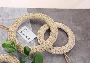 Close-up of two round hand-woven grass placemats with hanging loops for wall storage