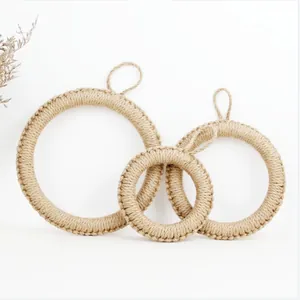 Detail of three handmade woven jute trivets with hanging loops on white background