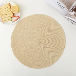 Gros plan d'un set de table rond beige en papier tissé avec une texture en spirale