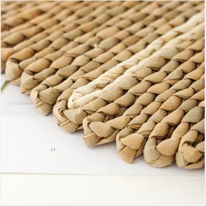 Macro detail of hand-woven straw place mat showing natural fiber texture and thick craftsmanship