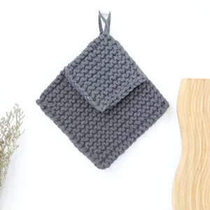 Macro detail of thick dark grey hand-woven cotton rope coaster with hanging loop