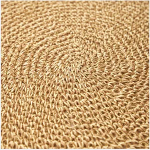 Dettaglio macro di una tovaglietta rotonda in paglia intrecciata con trama a spirale