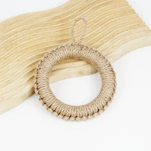 Detail of hand-woven jute placemat with hanging loop on a natural wavy wooden board