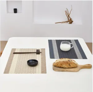 Close-up of woven heat-resistant placemats in beige and deep gray-blue striped patterns