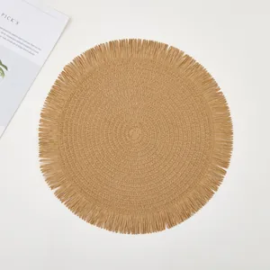 Detail of round woven placemat featuring fringe edges and natural spiral texture