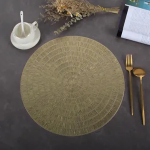Detailed view of champagne gold round PVC placemat with spiral woven heat-resistant texture