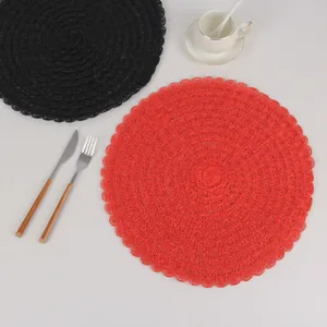 Detail of red and black round woven placemats in a minimalist creative dining table setting