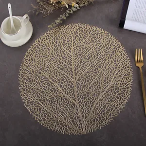 Golden round hollow PVC placemat with leaf vein texture on dark stone table