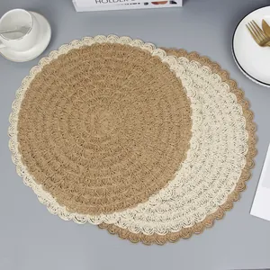 Detail of hand-woven round placemats with scallop edges in khaki and cream white tones