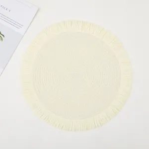 Close-up of circular woven placemat featuring spiral texture and boho fringe edges