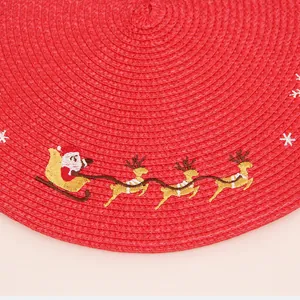 Round red woven Christmas placemat featuring embroidered Santa Claus and golden reindeer