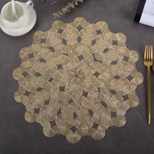Detail of round hollow gold PVC placemat with woven geometric wave patterns and metallic finish