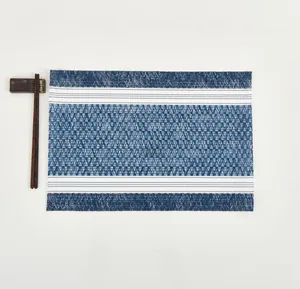 Detail of blue and white geometric woven placemat with Japanese style wooden chopsticks